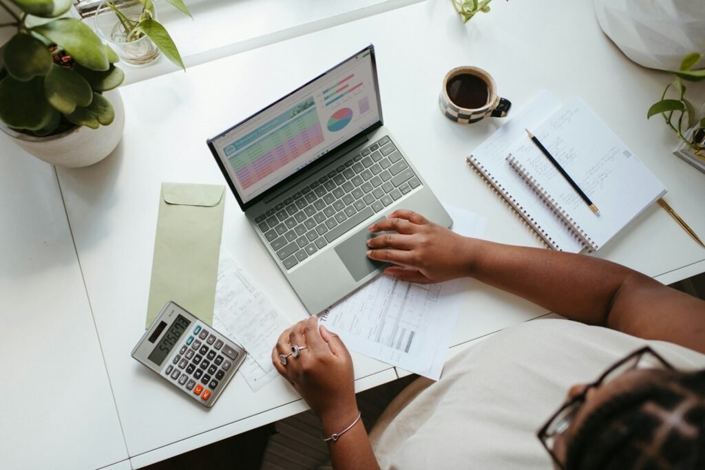 A top-down view of a desk with tax and bookkeeping information, with a calculator and a cup of coffee