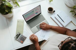 A top-down view of a desk with tax and bookkeeping information, with a calculator and a cup of coffee