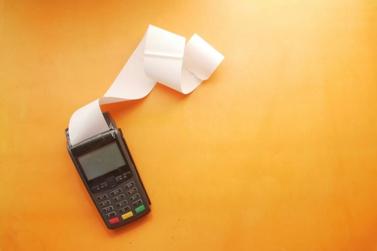 Receipt maker software concept showing a card payment terminal printing a receipt on a yellow background.
