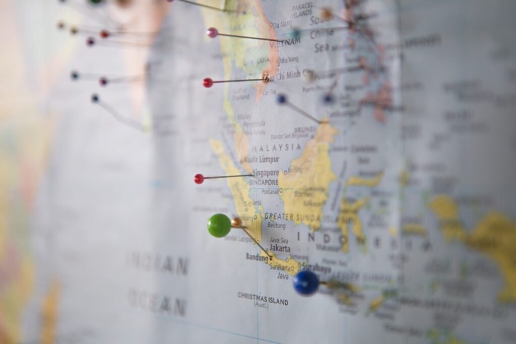A close-up of a world map with colored pins marking multiple locations, representing a distributed contractor roster.