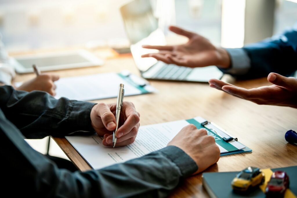 A freelancer signing a business insurance contract to prevent damage if faced with a loss of earnings situation