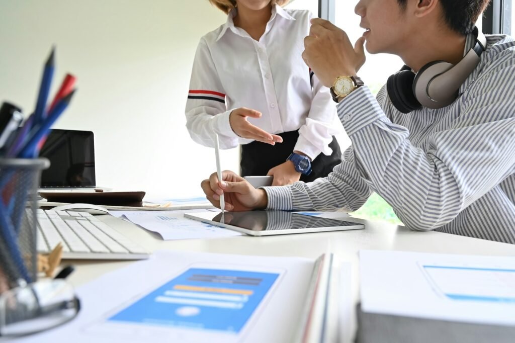 A person holding a pen and writing notes on white paper at a desk, planning a project brief.