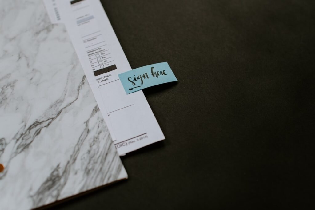 A calculator, pen, and financial paperwork laid out on a desk for tracking business deductions.