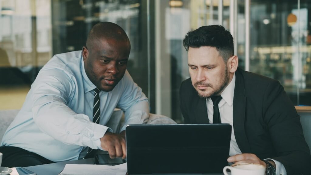 Two business colleagues looking at a laptop together and discussing a project.