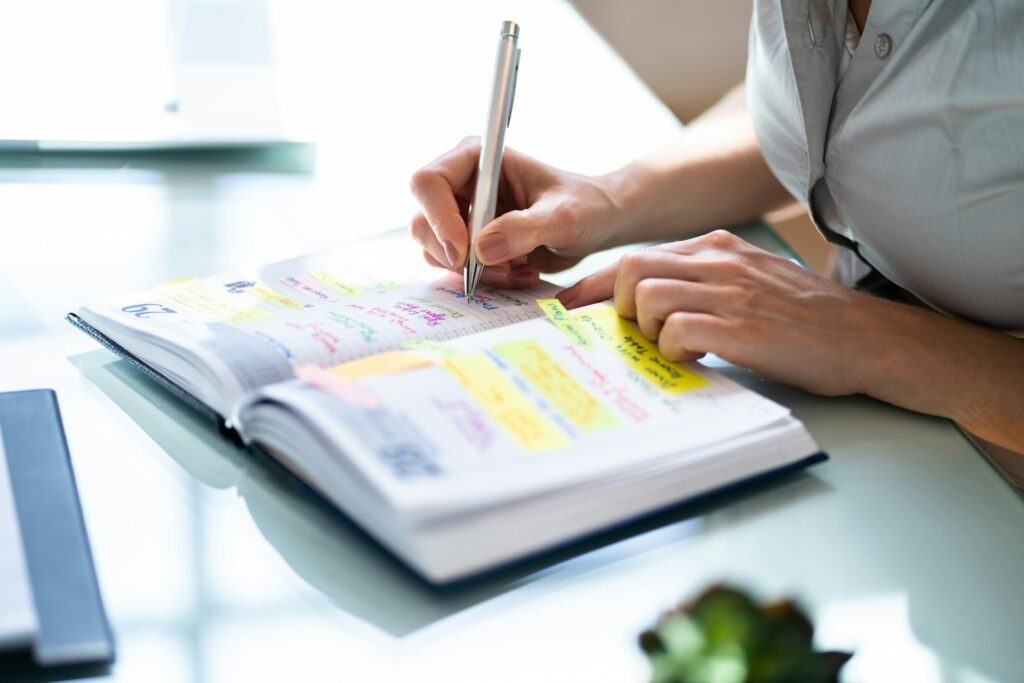 Hands with a calendar and planner, blocking anchor tasks into a freelance schedule