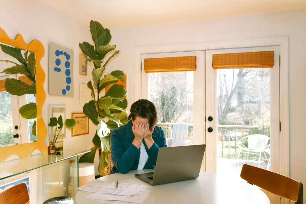 Freelancer at a table with a laptop, facing the feast-and-famine swings of solo work