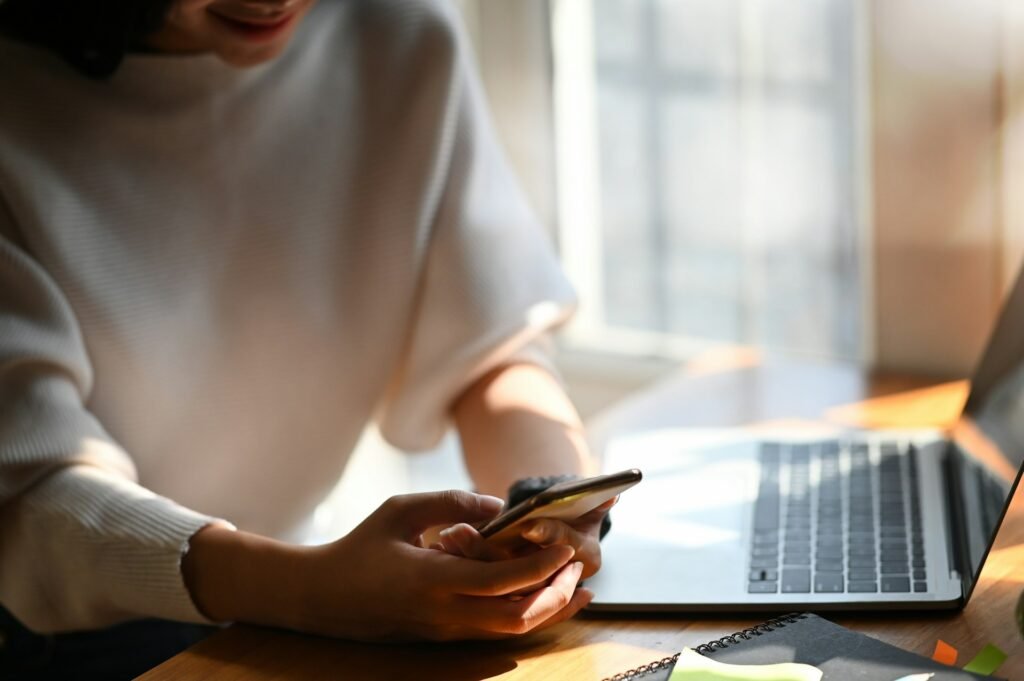 Freelancer checking her smartphone on a break after clearing her inbox with an email app