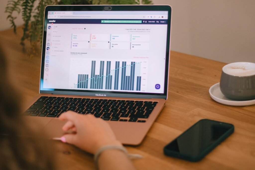 Freelancer reviewing cash flow charts on a laptop while comparing forecasting tools