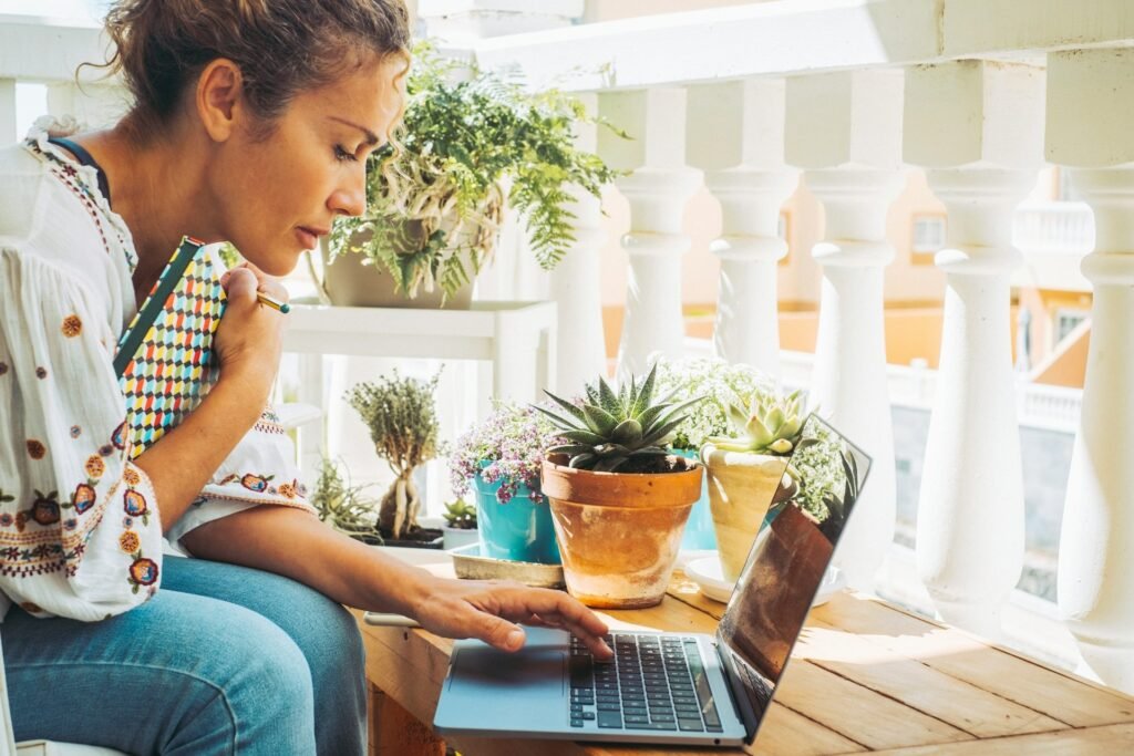 Freelancer working on a laptop from an outdoor terrace, running a steady work-from-home week
