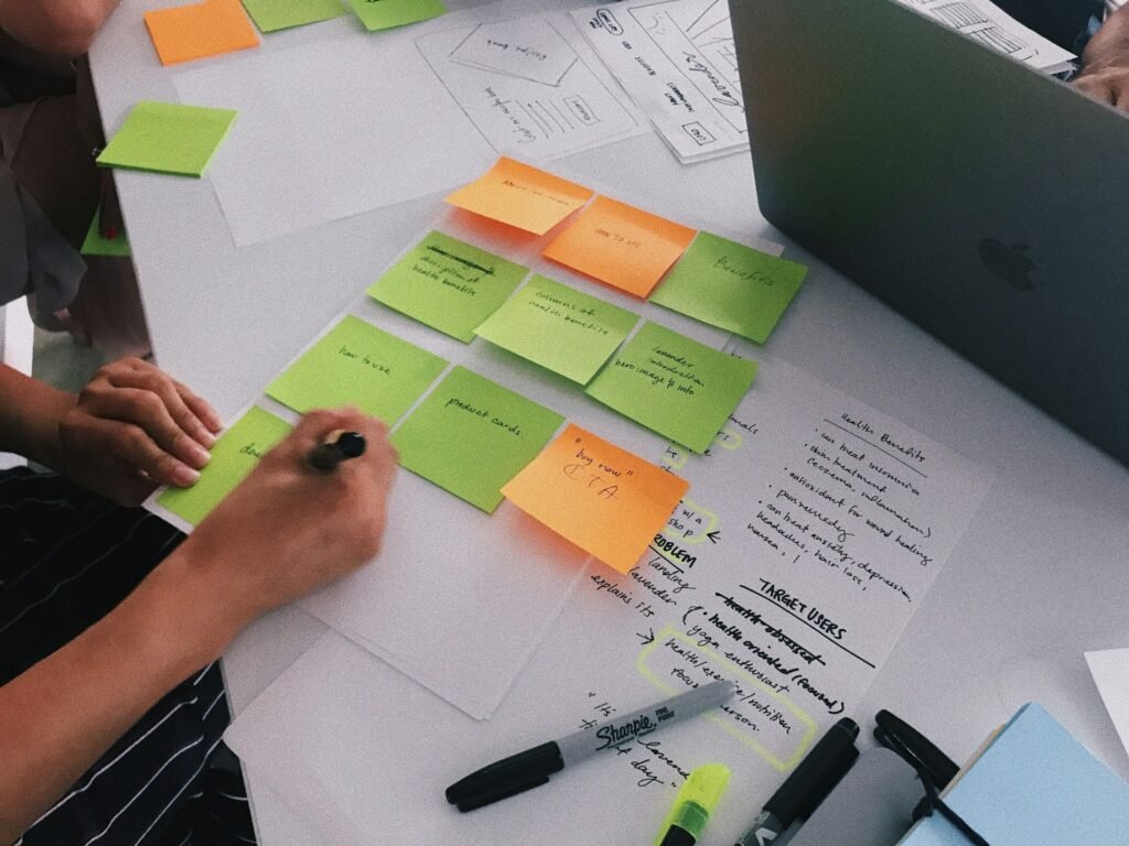 Freelancer writing tasks on sticky notes, the analog version of a project management app