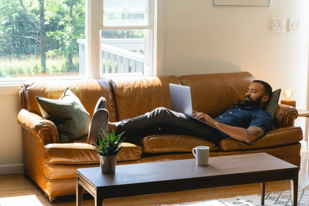 Freelancer sitting on a couch with a laptop, showing how easily focus slips when working from home