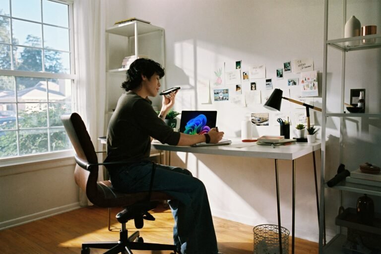 Freelancer working at a sunlit home-office desk by the window, illustrating how to stay focused when working from home.