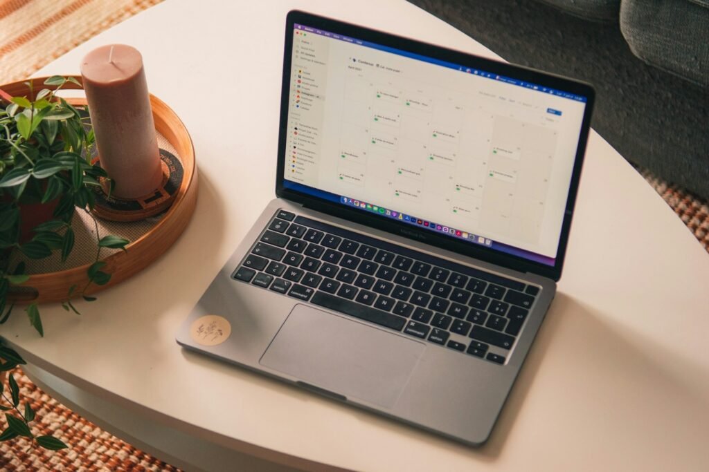 MacBook Pro open on a clean white table, ready for note-taking and focused freelance work