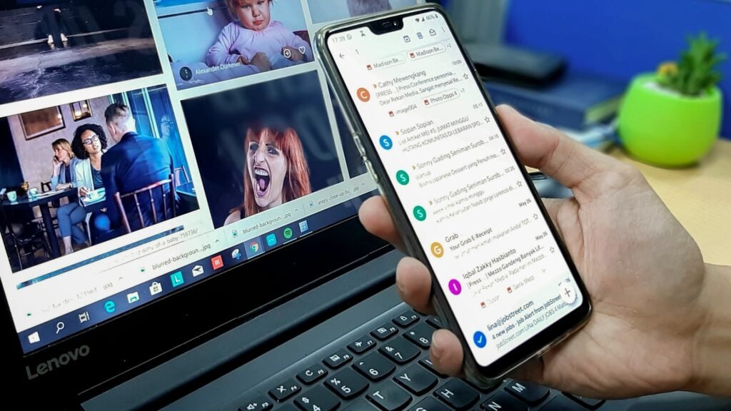 Freelancer using a smartphone and laptop together to manage their inbox with free email tools