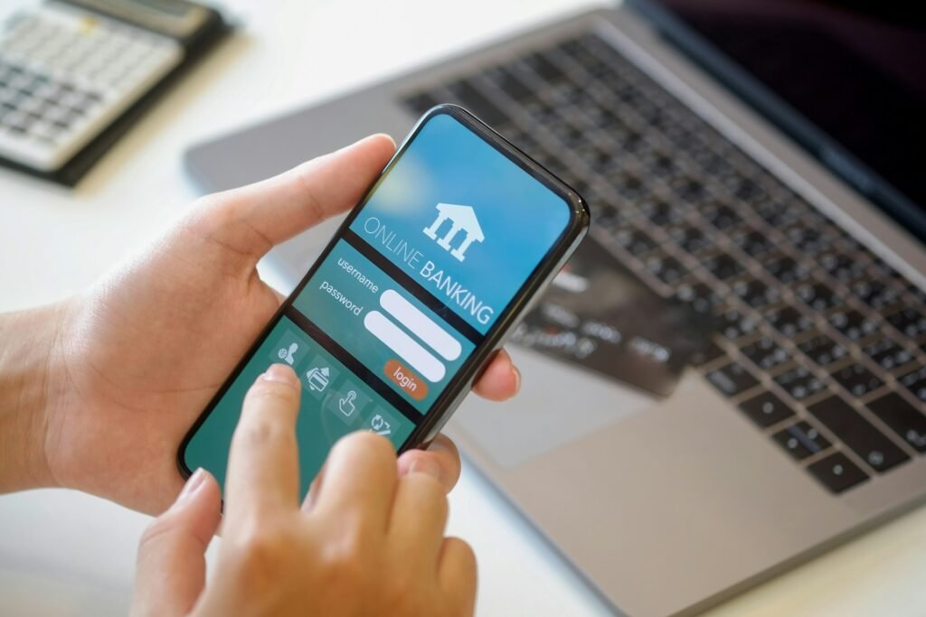 Man holding a smartphone showing a mobile banking app, one of the best banking apps for freelancers