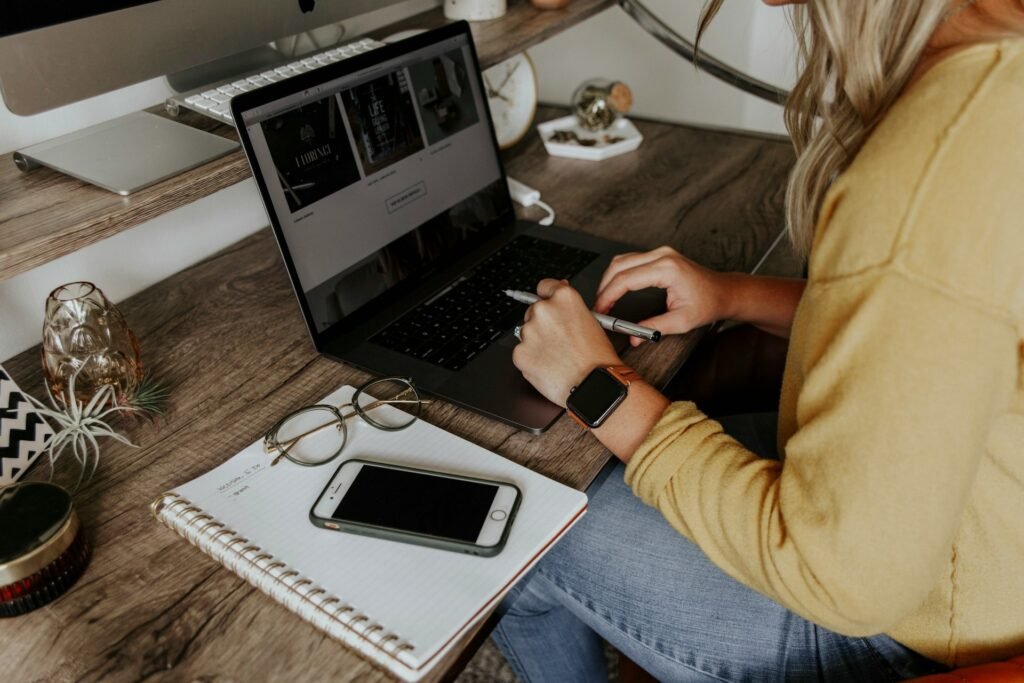 Freelancer in jeans working on a MacBook with their phone out of reach to stay focused