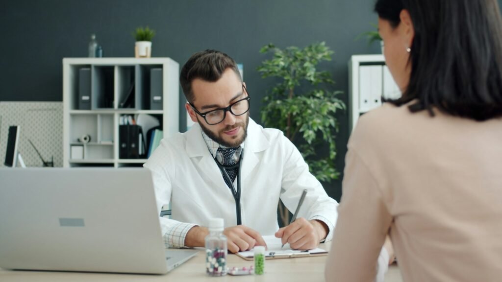 Doctor writing notes with a patient, illustrating the self-employed health insurance deduction