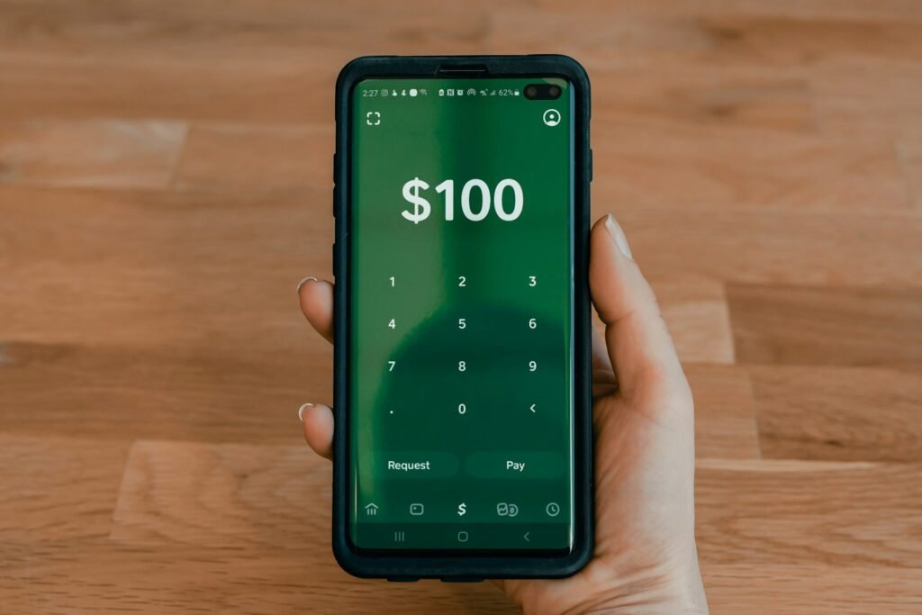 Freelancer holding a smartphone, sending an invoice from a mobile invoicing app