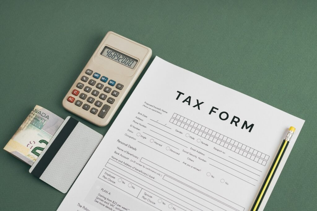 Tax form beside a calculator and pen, used to work out a freelancer's biggest tax deductions