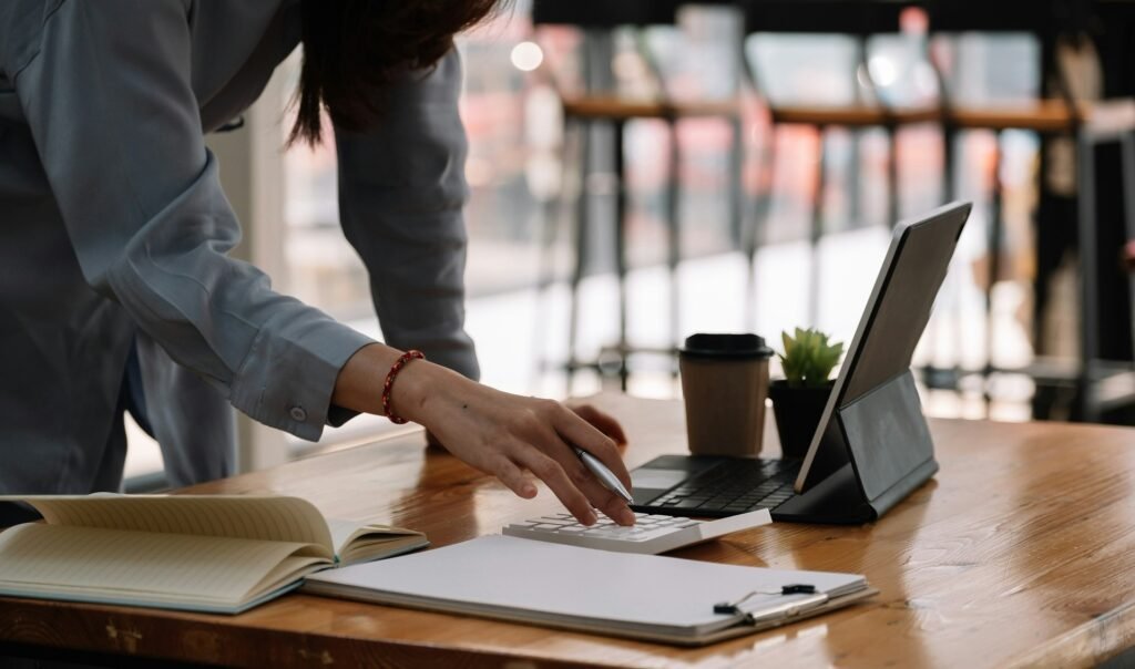 Freelancer at an office desk using a calculator, weighing up the real cost of "free" productivity tools