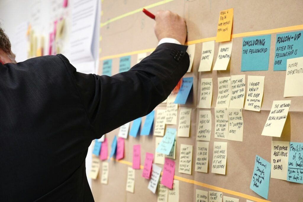 A corkboard covered in Post-It notes for project management