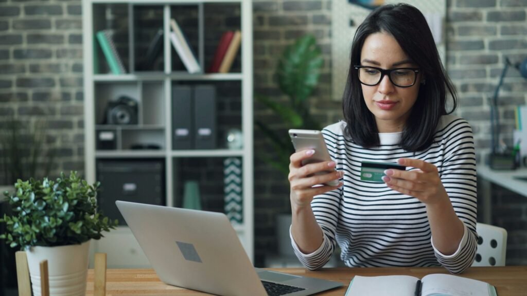 Freelancer checking invoice payment notifications on her phone after automating billing