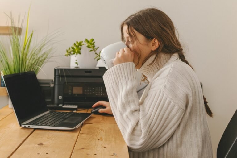 Freelancer creating an invoice in Google Sheets on a laptop at her desk