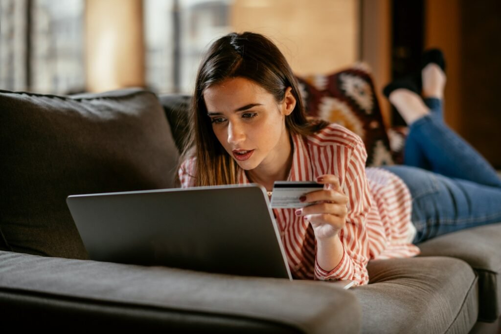 Freelancer on a sofa using a laptop to check her invoices