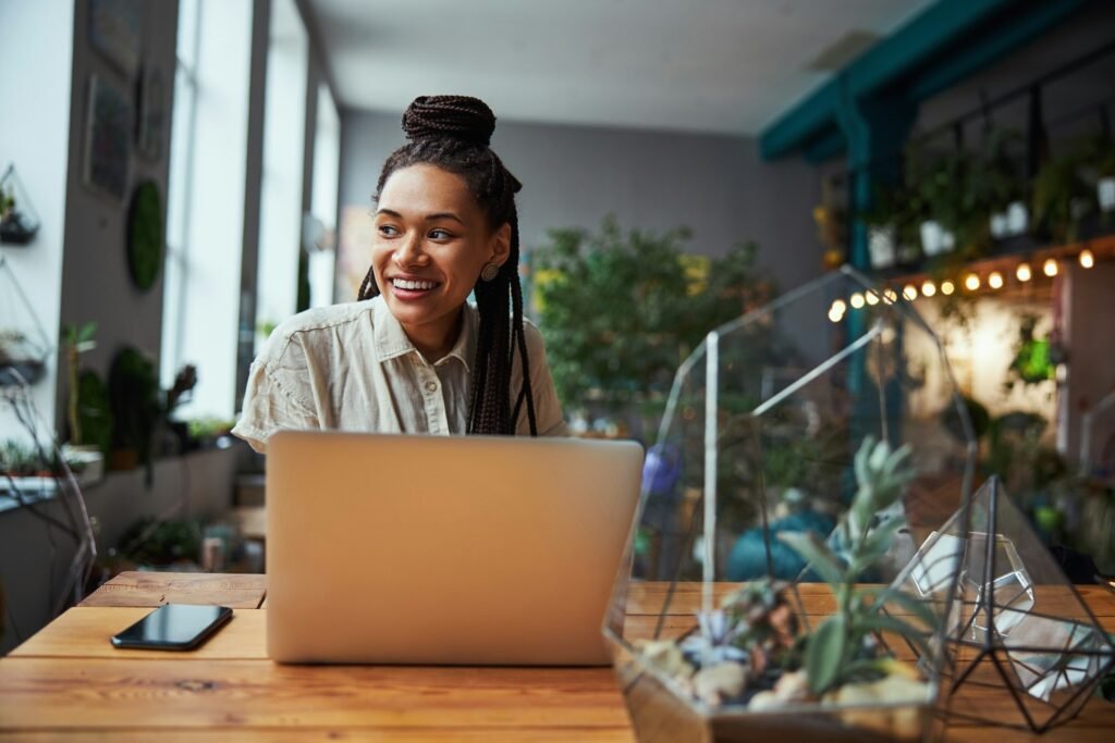 Freelancer sending an invoice by email from a laptop in her workshop