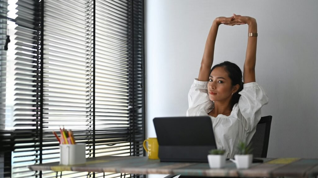 Freelancer stretching at her desk after finishing a productive day using the 1-3-5 rule