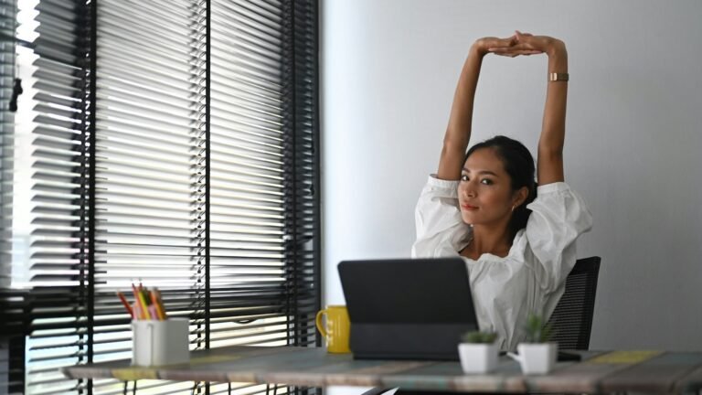 Freelancer stretching at her desk after finishing a productive day using the 1-3-5 rule