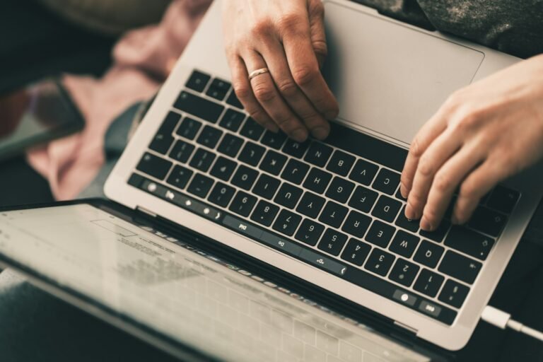 Freelancer using a laptop to set up invoice automation for recurring client billing
