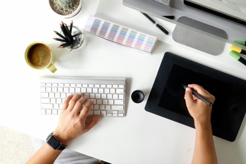 Freelancer working on a graphics tablet with automated workflow tools running in the background