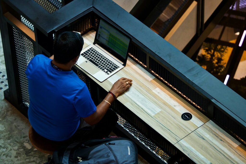 Freelancer working on a laptop comparing invoice tracking software and spreadsheet options