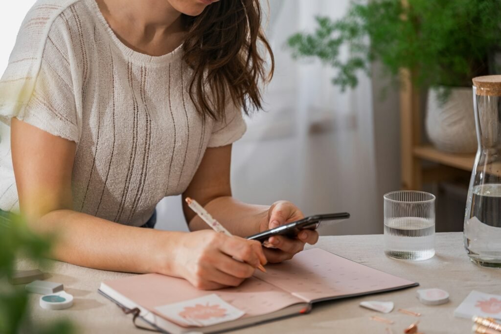 Freelancer writing a to-do list by hand before switching to an AI to-do list app 
