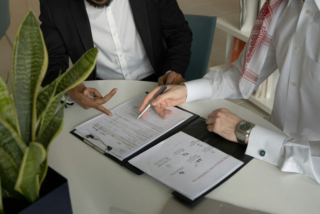 Two people reviewing a freelance contract template with papers and a pen on the table
