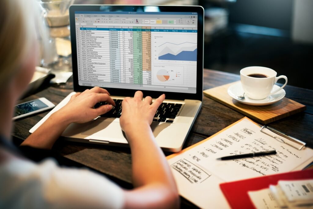 Freelancer working on a budget spreadsheet with charts on a laptop