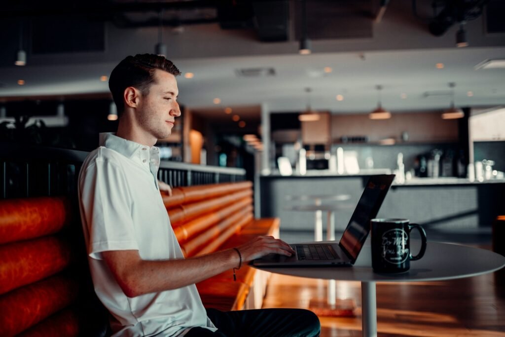 Freelancer working on a laptop at a café table with a coffee