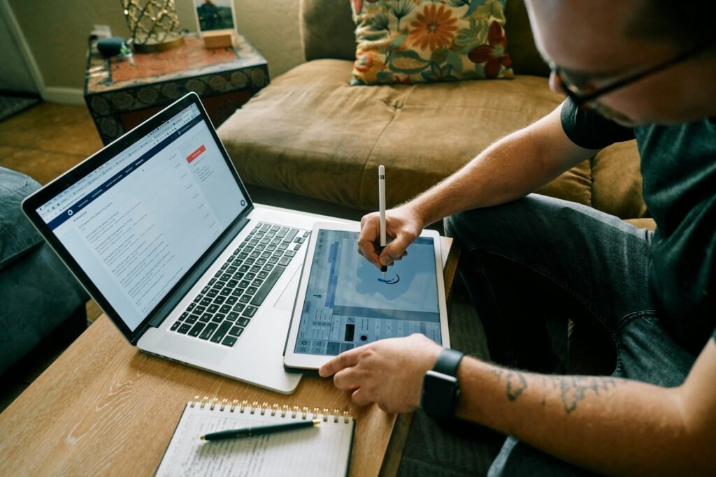 Freelancer working across a laptop and a tablet with a stylus
