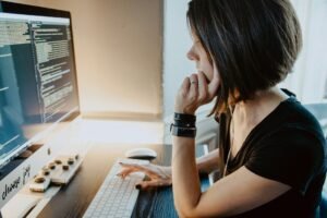 Freelancer working at a desktop computer with code on screen
