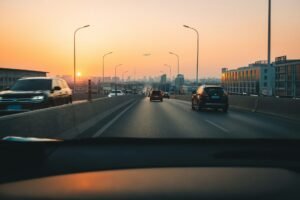 Driver's view through a windscreen of a multi-lane road at sunset
